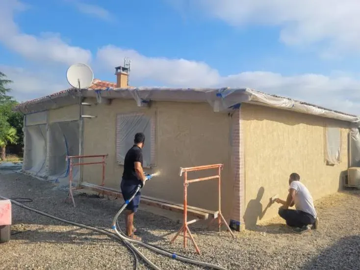 L’équipe LMA Maçon Façadier 82 projette un enduit de façade sur une maison