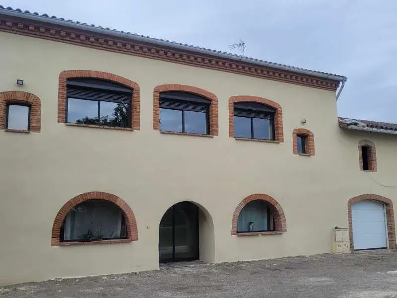Ravalement de façade réalisé par LMA Maçon Façadier 82 : enduit neuf et arcs en brique conservés